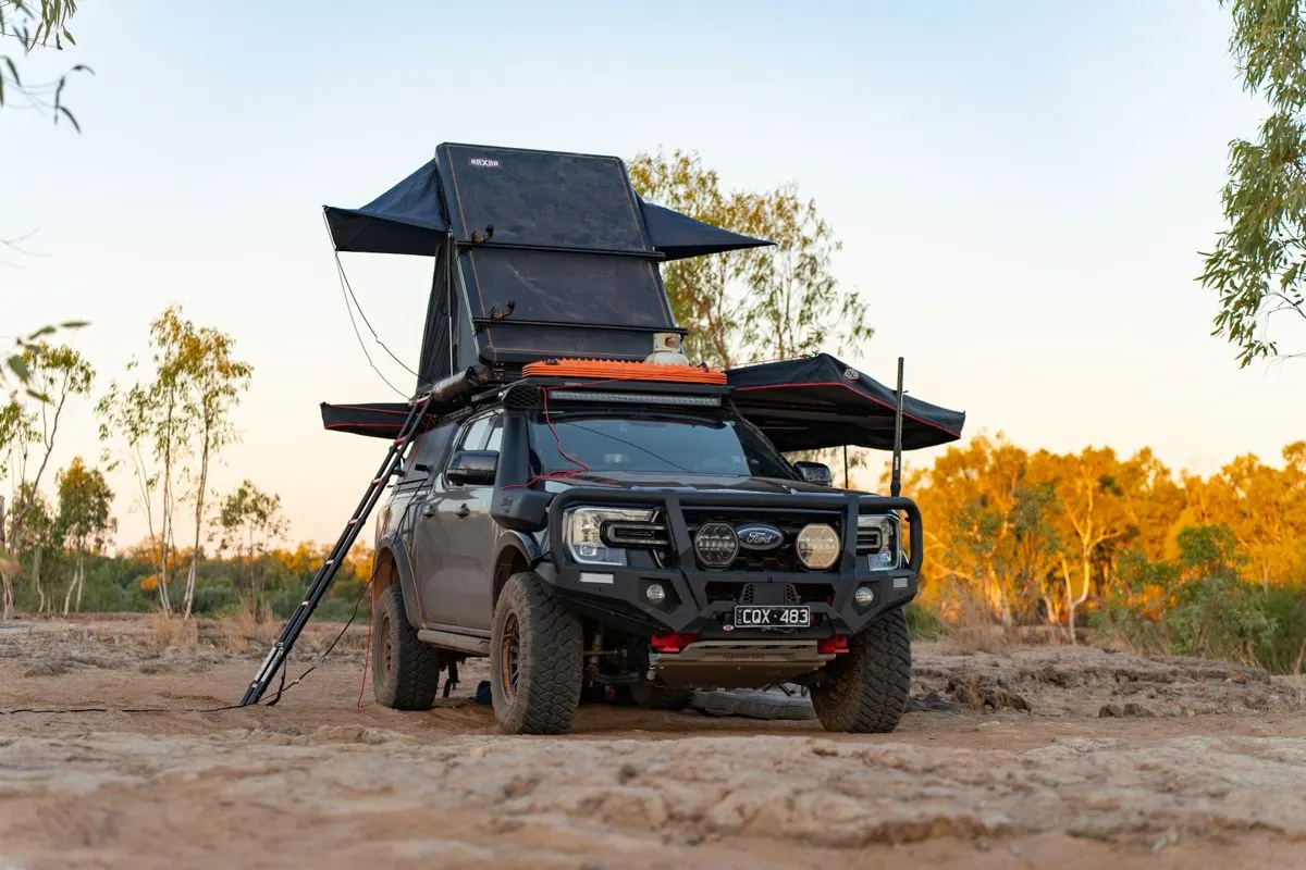 Rooftop tent open on a ute at dusk