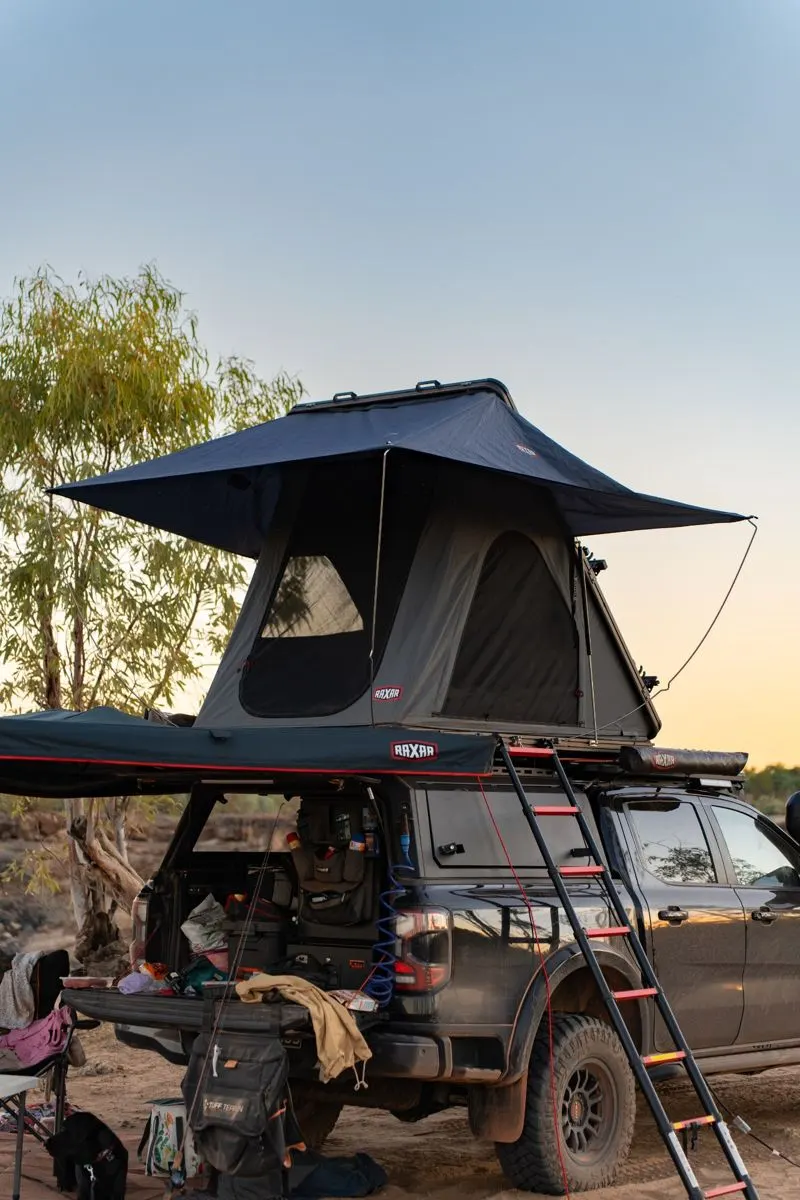 Ford Ranger with a Raxar rooftop tent and ladder on its canopy and a Raxar awning at a dusk camp