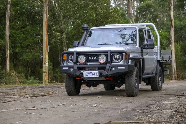 Toyota LandCruiser 79 dual cab with an alloy tray, bull bar and snorkel on a forest track
