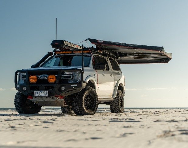 Ford 4WD with bull bar, UHF antenna and awning on a beach